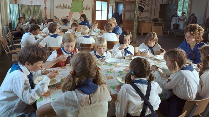 Jungpioniere in Uniform beim Essen.