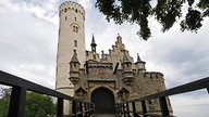 Blick über eine Holzbrücke auf Schloss Lichtenstein