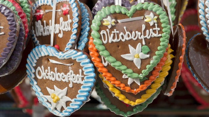 Viele Lebkuchenherzen mit der Aufschrift "Oktoberfest" nebeneinander und übereinander 