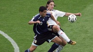 Torsten Frings bedrängt den ballführenden Argentinier Juan Riquelme