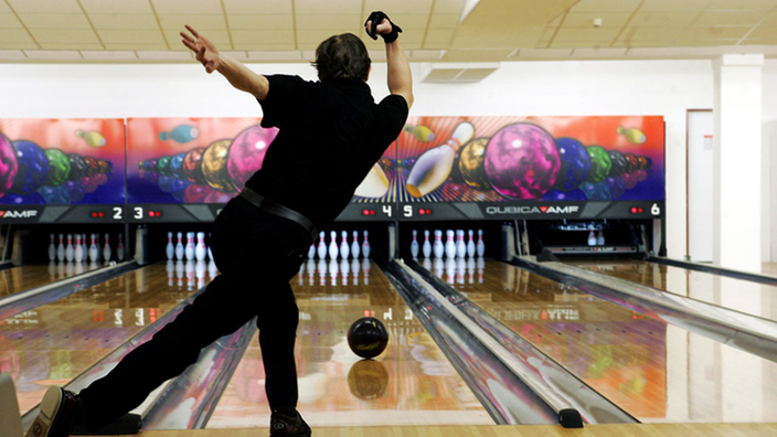 Mann von hinten beim Bowling.