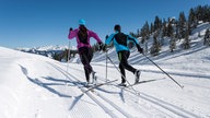 Zwei Langläufer ziehen ihre Spuren durch den Schnee.