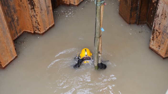 Ein Industrietaucher taucht in der Baustelle eines Abwasserkanals in Köln.