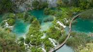 Blick von oben auf Seen und Wasserfälle im Plitvice-Nationalpark.