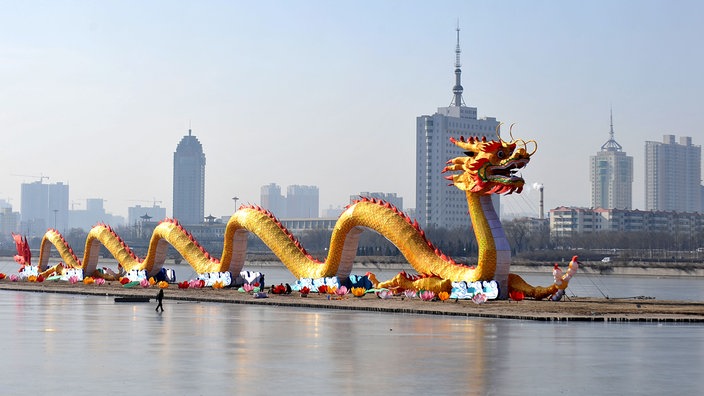 Riesiger Drache vor Skyline einer Stadt in China