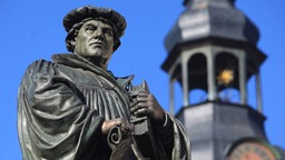 Denkmal des Reformators Martin Luther auf dem Marktplatz mit dem Turm der St. Andreaskirche im Hintergrund