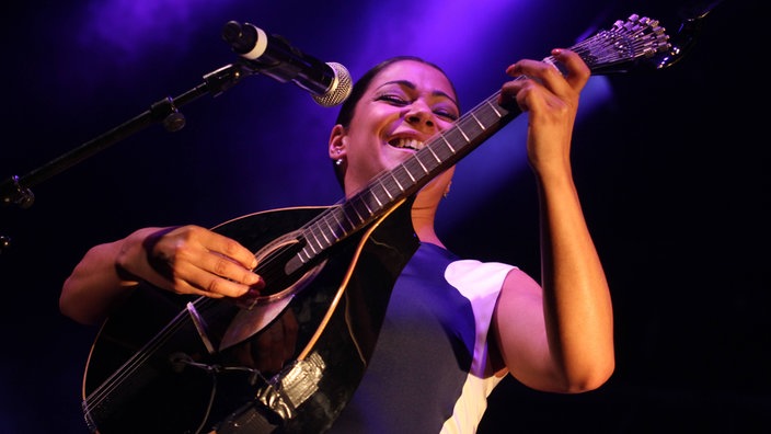 Eine Frau spielt die portugiesische Gitarre