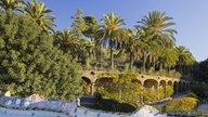 Mosaikverzierte Mauer im Park Guell, im Hintergrund Säulengang