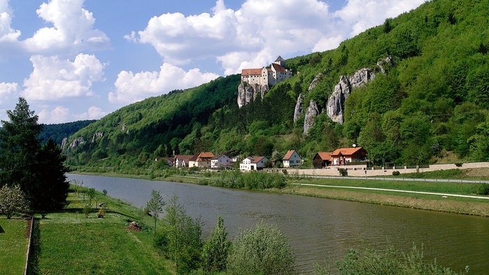 Kanal vor grünen Hügeln.