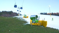 Schneekanonen auf grüner Piste