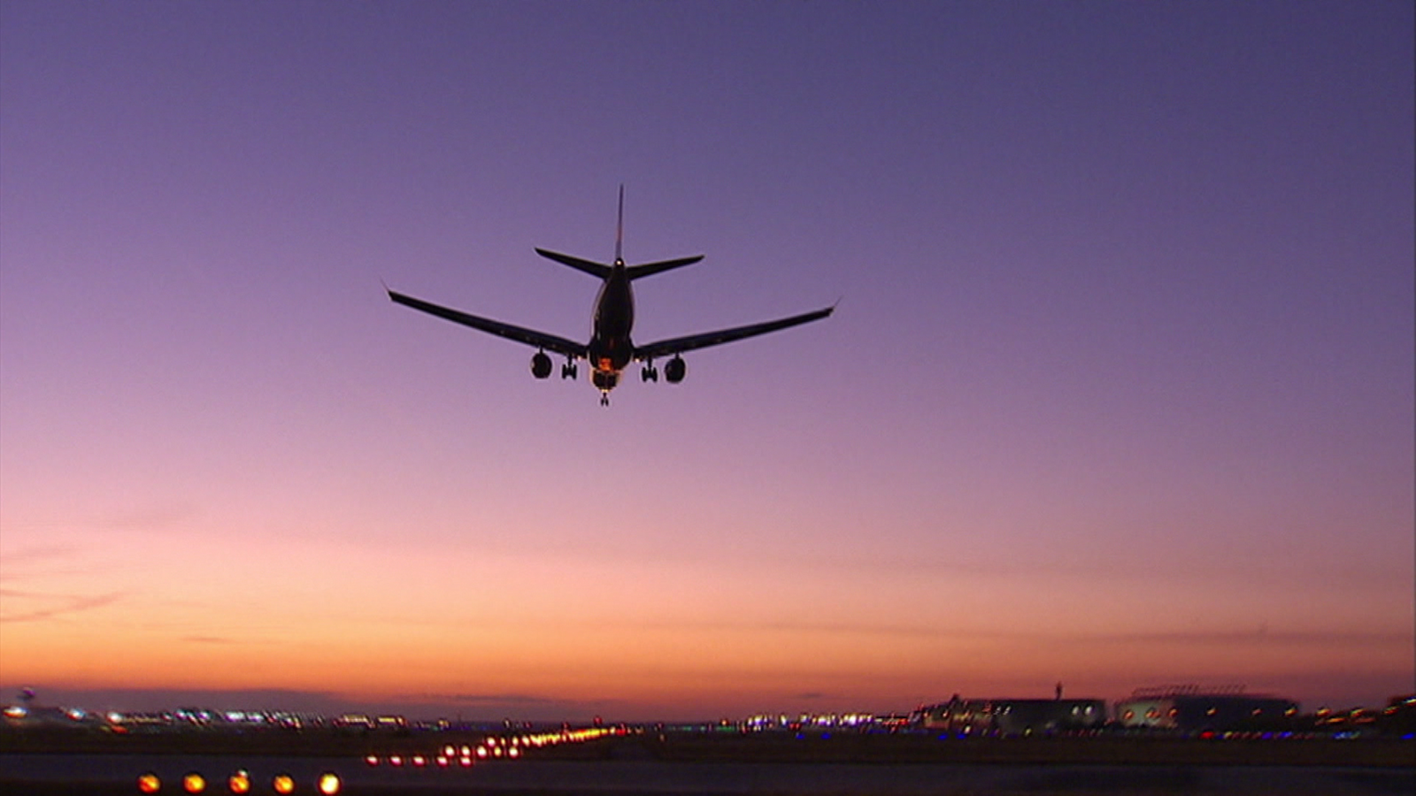 Flughafen und landendes Flugzeug in der Dämmerung