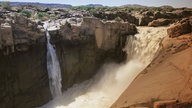 Ein tosender Wasserfall stürzt in einen Canyon.