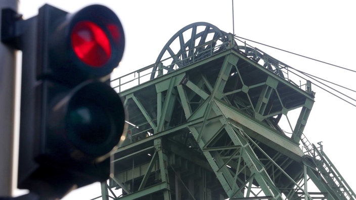 Rote Ampel neben einem Förderturm.